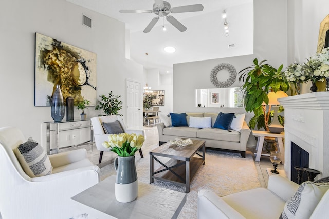 6392 Long Key Ln, Boynton Beach, FL 33472 - living room featuring a fireplace with raised hearth, ceiling fan, a chandelier, and a towering ceiling