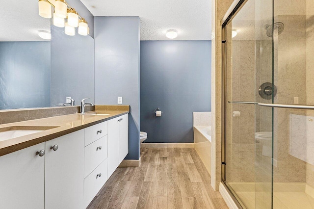 3995 Majestic Palm Way, Delray Beach, FL 33445 - bathroom with wood finished floors, a bath, double vanity, a stall shower, and a textured ceiling
