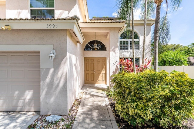 3995 Majestic Palm Way, Delray Beach, FL 33445 - view of exterior entry featuring stucco siding and a tiled roof