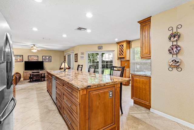 3995 Majestic Palm Way, Delray Beach, FL 33445 - kitchen with stainless steel appliances, brown cabinetry, open floor plan, light stone countertops, and recessed lighting