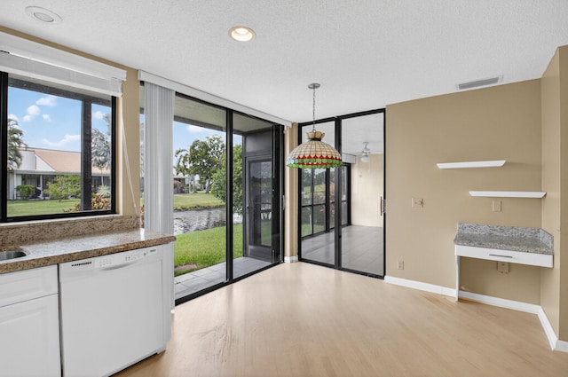 19630 Sawgrass Cir Unit 2901, Boca Raton, FL 33434 - unfurnished dining area with light wood-style floors, a water view, a textured ceiling, and a wall of windows