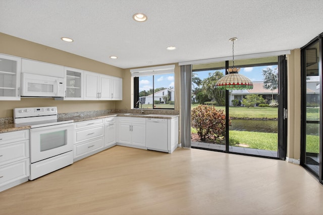 19630 Sawgrass Cir Unit 2901, Boca Raton, FL 33434 - kitchen with white appliances, light wood finished floors, white cabinets, glass insert cabinets, and a textured ceiling