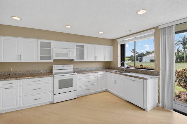 19630 Sawgrass Cir Unit 2901, Boca Raton, FL 33434 - kitchen featuring white appliances, healthy amount of natural light, light wood-style floors, glass insert cabinets, and a textured ceiling