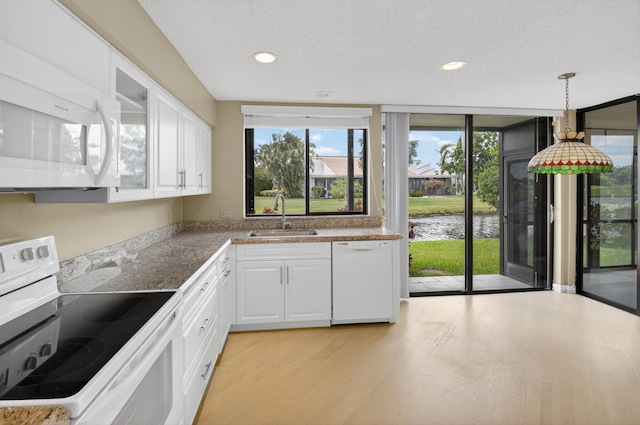 19630 Sawgrass Cir Unit 2901, Boca Raton, FL 33434 - kitchen with white appliances, a water view, white cabinets, light wood-style flooring, and glass insert cabinets