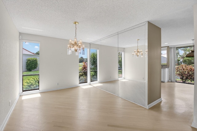 19630 Sawgrass Cir Unit 2901, Boca Raton, FL 33434 - unfurnished dining area with a chandelier, a textured ceiling, light wood finished floors, and healthy amount of natural light