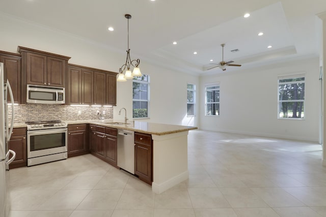 10479 SW Visconti Way, Port Saint Lucie, FL 34986 - kitchen featuring stainless steel appliances, tasteful backsplash, a ceiling fan, a peninsula, and a raised ceiling