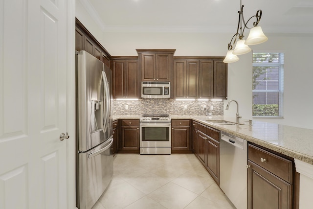 10479 SW Visconti Way, Port Saint Lucie, FL 34986 - kitchen with stainless steel appliances, backsplash, light stone counters, light tile patterned floors, and hanging light fixtures