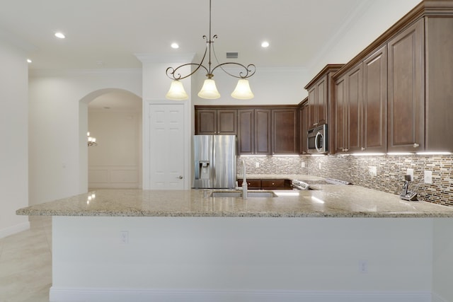 10479 SW Visconti Way, Port Saint Lucie, FL 34986 - kitchen featuring stainless steel appliances, arched walkways, light stone countertops, tasteful backsplash, and ornamental molding