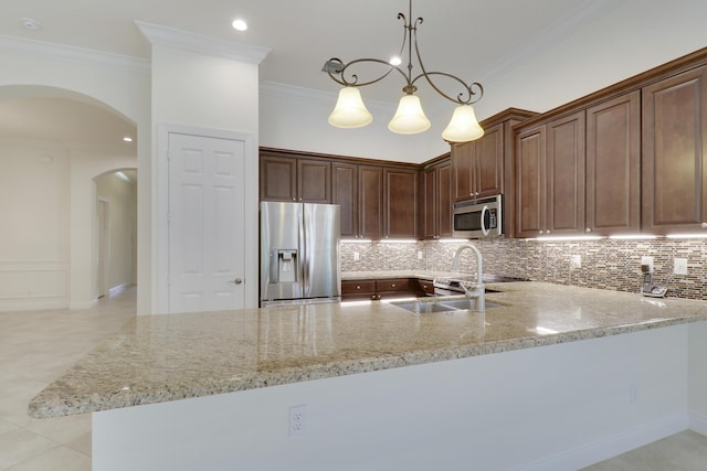 10479 SW Visconti Way, Port Saint Lucie, FL 34986 - kitchen with appliances with stainless steel finishes, arched walkways, light stone counters, tasteful backsplash, and a peninsula