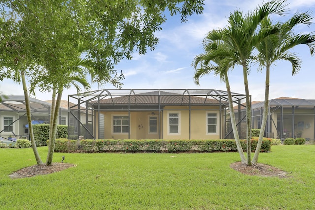 10479 SW Visconti Way, Port Saint Lucie, FL 34986 - back of property featuring a yard, stucco siding, glass enclosure, and a tile roof