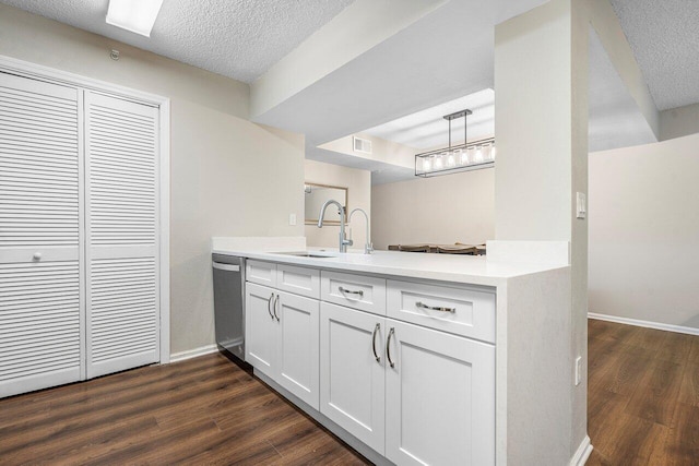 800 Scotia Dr Unit 102, Hypoluxo, FL 33462 - kitchen featuring stainless steel dishwasher, a peninsula, dark wood-style floors, light countertops, and a textured ceiling