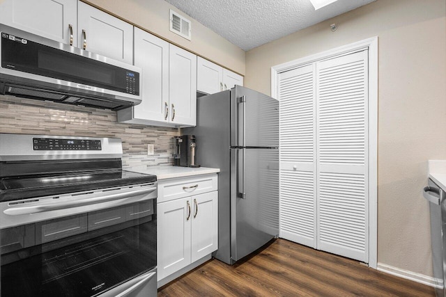 800 Scotia Dr Unit 102, Hypoluxo, FL 33462 - kitchen featuring appliances with stainless steel finishes, tasteful backsplash, dark wood-type flooring, white cabinets, and light countertops