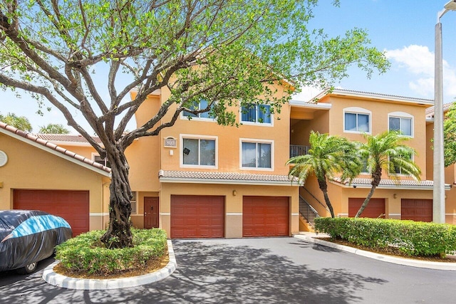 800 Scotia Dr Unit 102, Hypoluxo, FL 33462 - townhome / multi-family property with asphalt driveway, an attached garage, stucco siding, and a tiled roof