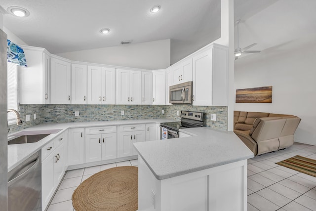 4386 SE Scotland Cay Way, Stuart, FL 34997 - kitchen featuring appliances with stainless steel finishes, light tile patterned floors, vaulted ceiling, a sink, and tasteful backsplash