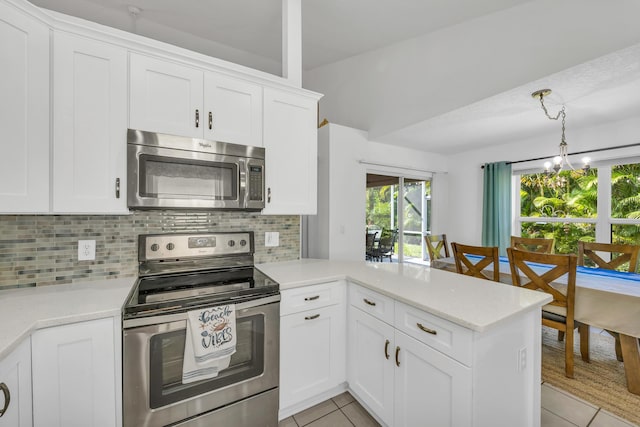 4386 SE Scotland Cay Way, Stuart, FL 34997 - kitchen with appliances with stainless steel finishes, light tile patterned flooring, a peninsula, and backsplash