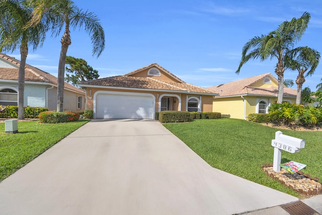 4386 SE Scotland Cay Way, Stuart, FL 34997 - mediterranean / spanish-style home with an attached garage, a front lawn, concrete driveway, and stucco siding