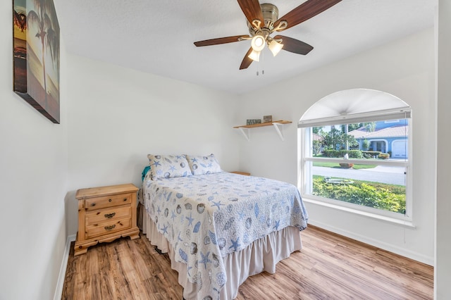 4386 SE Scotland Cay Way, Stuart, FL 34997 - bedroom with baseboards, light wood finished floors, and a ceiling fan