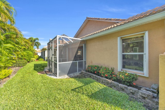 4386 SE Scotland Cay Way, Stuart, FL 34997 - view of side of property featuring stucco siding, a lawn, and glass enclosure