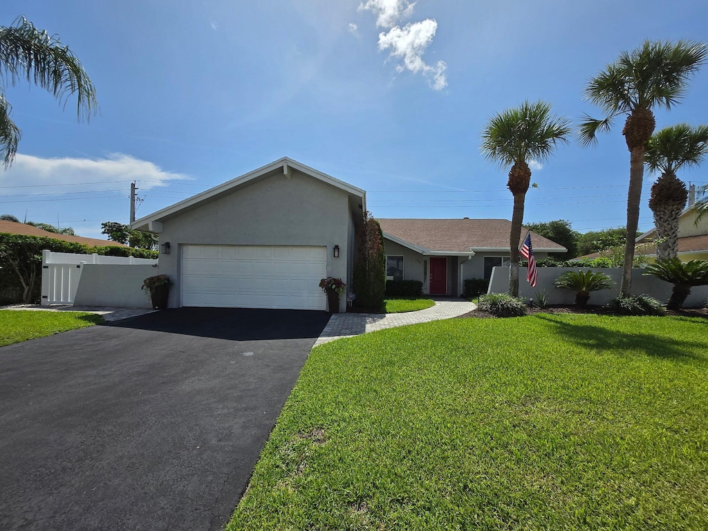 415 SW 27th Ave, Delray Beach, FL 33445 - single story home featuring asphalt driveway, stucco siding, and an attached garage