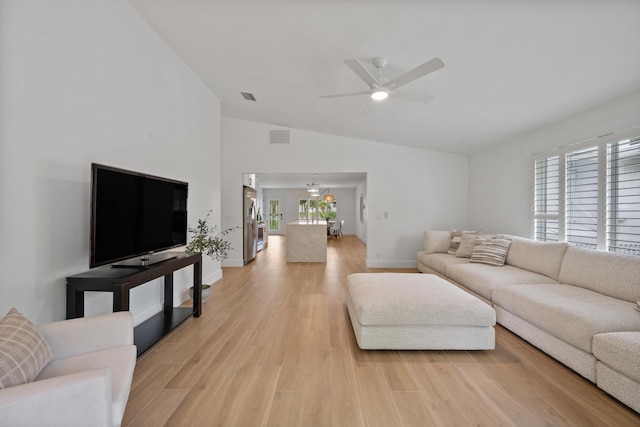 1567 NE Sottong Ave, Jensen Beach, FL 34957 - living room featuring vaulted ceiling, a ceiling fan, baseboards, and light wood-style flooring