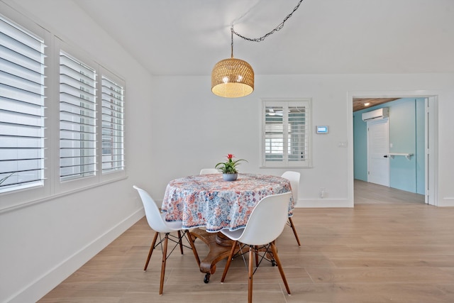 1567 NE Sottong Ave, Jensen Beach, FL 34957 - dining space with a wall mounted air conditioner, baseboards, and light wood finished floors