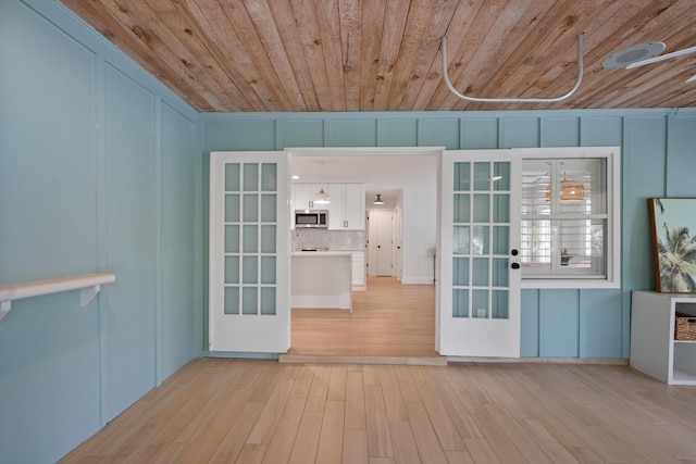 1567 NE Sottong Ave, Jensen Beach, FL 34957 - empty room featuring wood ceiling, light wood-type flooring, french doors, and a decorative wall