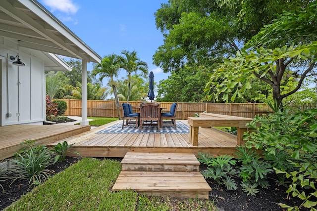 1567 NE Sottong Ave, Jensen Beach, FL 34957 - wooden terrace with outdoor dining space and a fenced backyard
