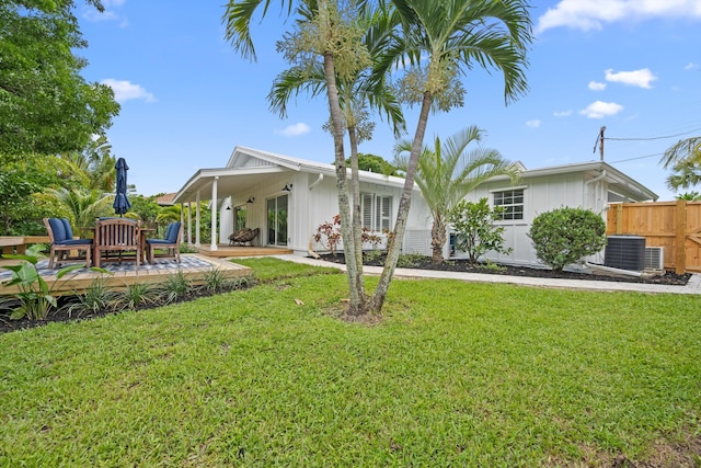 1567 NE Sottong Ave, Jensen Beach, FL 34957 - rear view of house featuring central air condition unit, board and batten siding, and a wooden deck