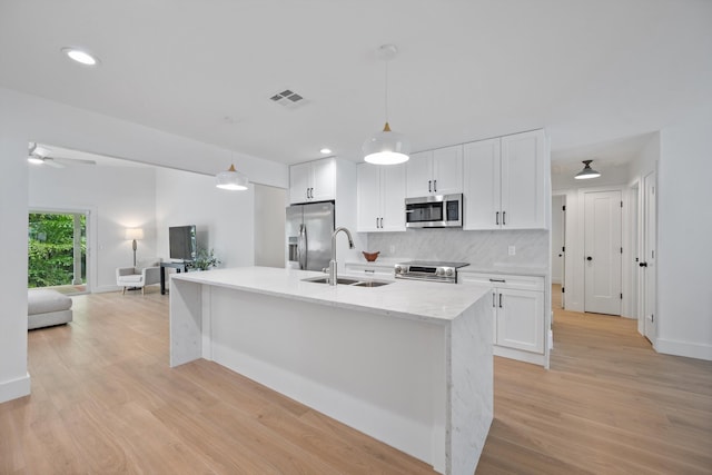 1567 NE Sottong Ave, Jensen Beach, FL 34957 - kitchen featuring appliances with stainless steel finishes, a sink, white cabinets, decorative backsplash, and recessed lighting