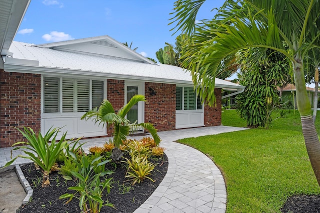 1567 NE Sottong Ave, Jensen Beach, FL 34957 - view of front facade with a front lawn and brick siding