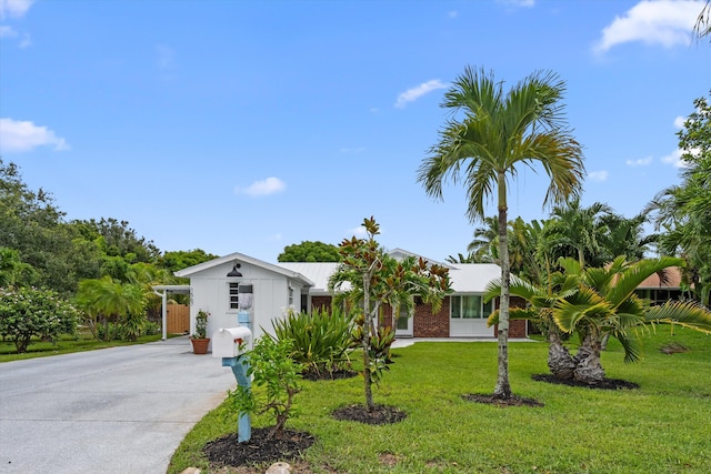 1567 NE Sottong Ave, Jensen Beach, FL 34957 - view of front of house featuring driveway and a front lawn