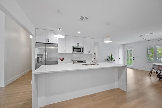 1567 NE Sottong Ave, Jensen Beach, FL 34957 - kitchen with stainless steel appliances, a sink, white cabinets, decorative backsplash, and baseboards