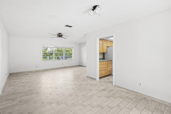 1830 Well Rd, Fort Pierce, FL 34945 - empty room with light wood-style floors, ceiling fan, and baseboards