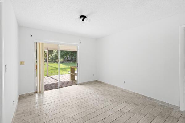 1830 Well Rd, Fort Pierce, FL 34945 - spare room with light wood-style floors, a textured ceiling, and baseboards