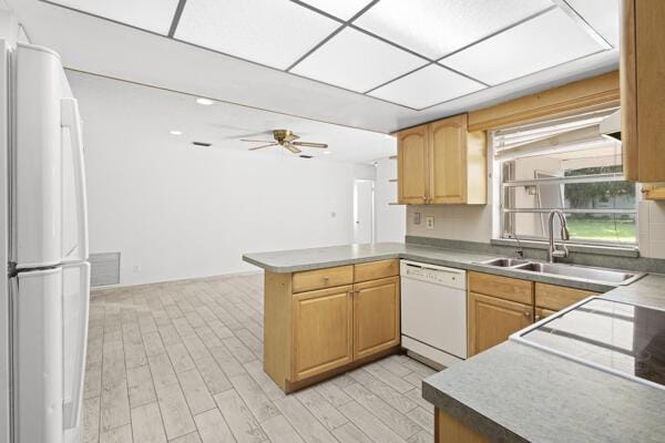 1830 Well Rd, Fort Pierce, FL 34945 - kitchen featuring white appliances, a peninsula, a ceiling fan, a sink, and light wood-style flooring