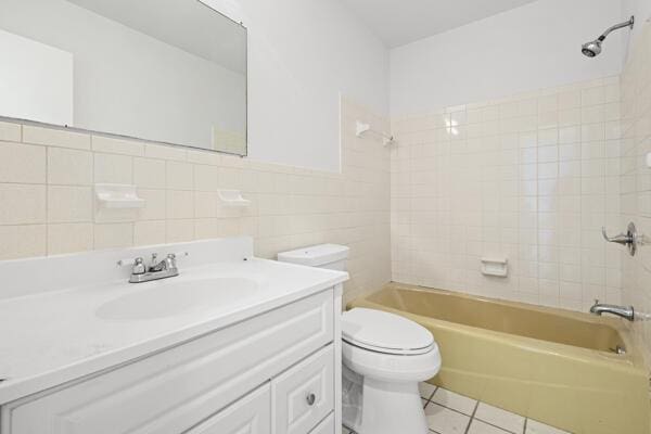 1830 Well Rd, Fort Pierce, FL 34945 - bathroom with tile patterned flooring, tile walls, toilet, shower / bath combination, and vanity