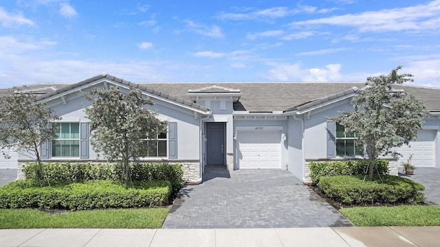 14556 Wiley Range Rd, Delray Beach, FL 33446 - view of front of home with a garage, decorative driveway, a tiled roof, and stucco siding