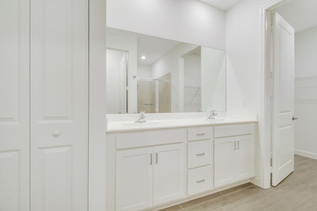 14556 Wiley Range Rd, Delray Beach, FL 33446 - full bathroom with a stall shower, double vanity, a walk in closet, and wood finished floors