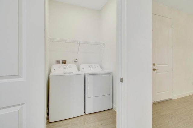 14556 Wiley Range Rd, Delray Beach, FL 33446 - washroom with washing machine and clothes dryer and light wood-style flooring
