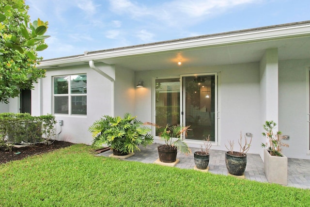 14556 Wiley Range Rd, Delray Beach, FL 33446 - rear view of house featuring stucco siding, a lawn, and a patio