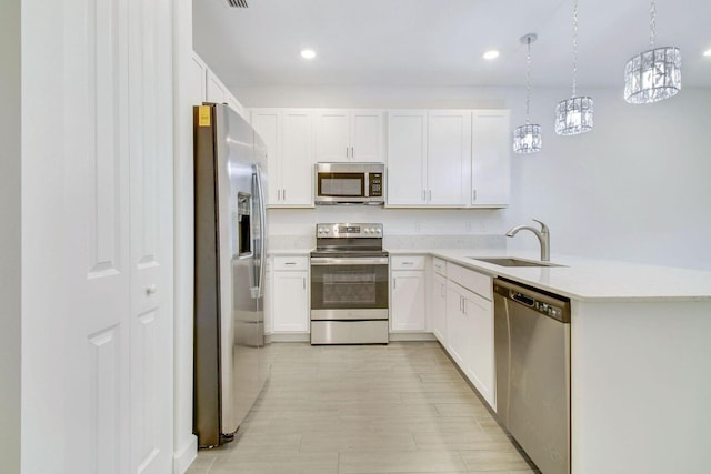 14556 Wiley Range Rd, Delray Beach, FL 33446 - kitchen with stainless steel appliances, white cabinets, light countertops, a chandelier, and a peninsula