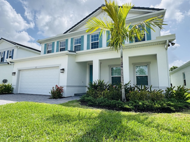163 SW Pomeroy St, Stuart, FL 34997 - view of front facade featuring driveway, an attached garage, stucco siding, and a front lawn