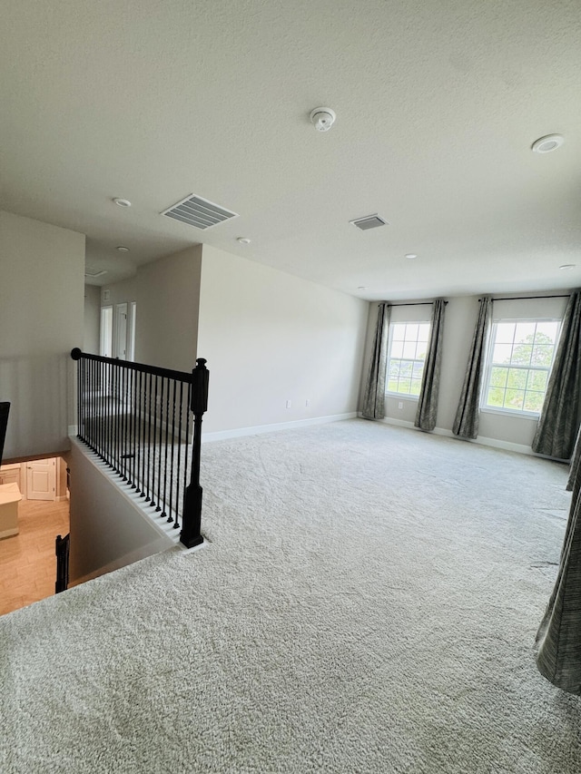 163 SW Pomeroy St, Stuart, FL 34997 - spare room featuring light colored carpet, a textured ceiling, baseboards, and a smoke detector