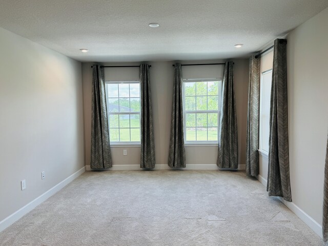 163 SW Pomeroy St, Stuart, FL 34997 - spare room featuring carpet, a textured ceiling, and baseboards