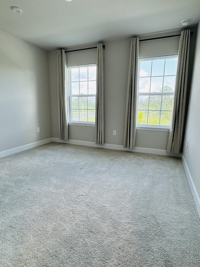 163 SW Pomeroy St, Stuart, FL 34997 - empty room with carpet floors, baseboards, and a textured ceiling