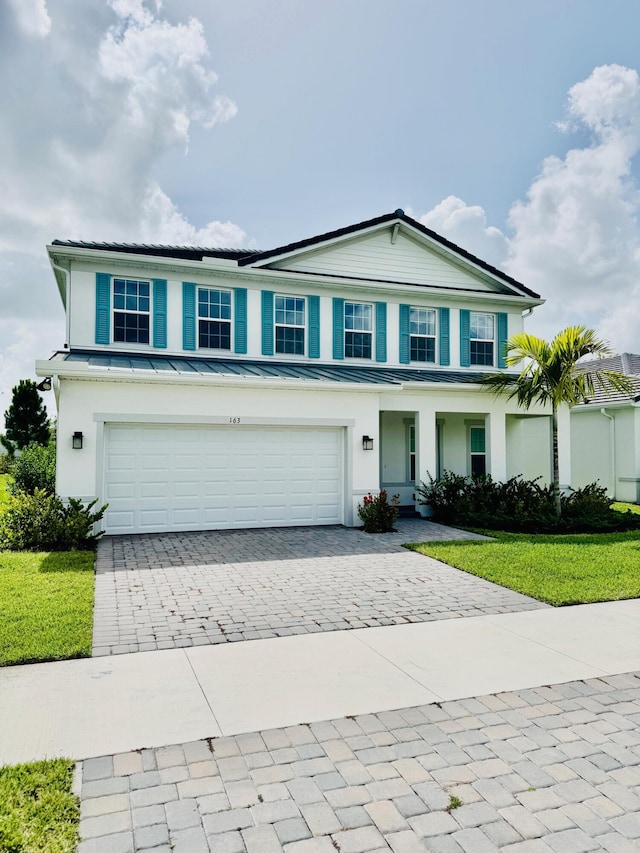 163 SW Pomeroy St, Stuart, FL 34997 - view of front facade with decorative driveway, a garage, and a front lawn