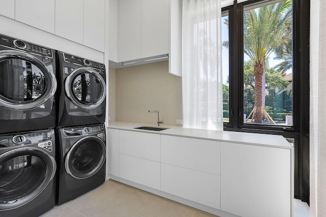 207 W Coconut Palm Rd, Boca Raton, FL 33432 - laundry room with stacked washer and clothes dryer, plenty of natural light, cabinet space, and light tile patterned floors