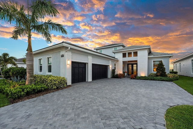 8650 SW Felicita Way, Port Saint Lucie, FL 34987 - view of front of home with an attached garage, decorative driveway, stucco siding, and french doors