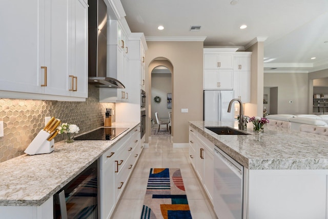 8650 SW Felicita Way, Port Saint Lucie, FL 34987 - kitchen featuring black appliances, wine cooler, wall chimney exhaust hood, crown molding, and a kitchen island with sink