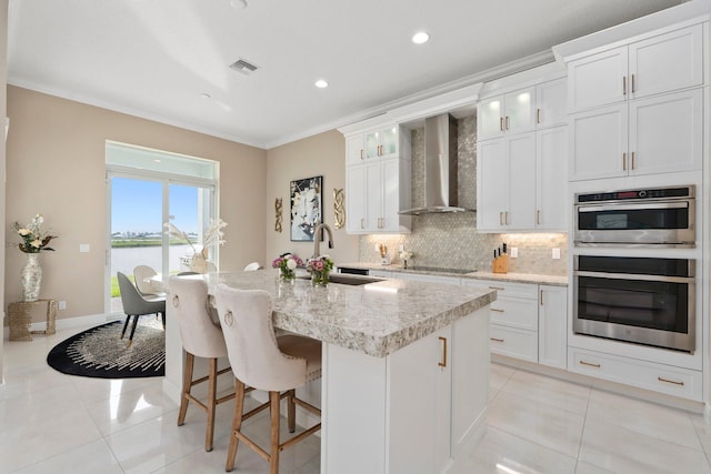 8650 SW Felicita Way, Port Saint Lucie, FL 34987 - kitchen with wall chimney range hood, light tile patterned flooring, tasteful backsplash, ornamental molding, and black electric cooktop